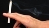 Ruka držící zapálenou cigaretu
