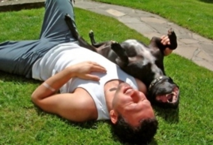 Muž se psem ležící na trávě